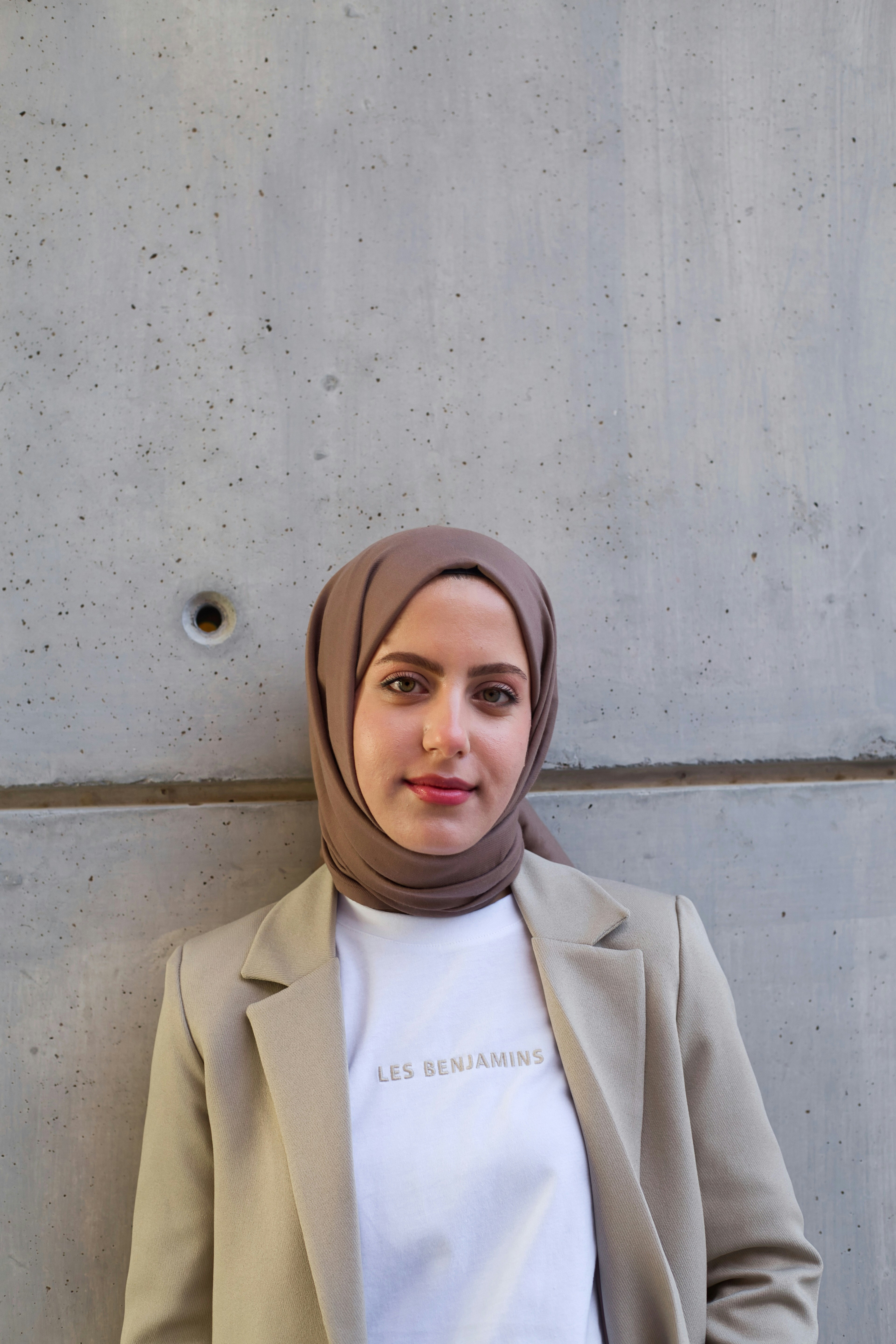 Foto zum Thema Eine Frau mit Kopftuch steht an einer Wand Kostenloses Bild zu Grau auf Unsplash