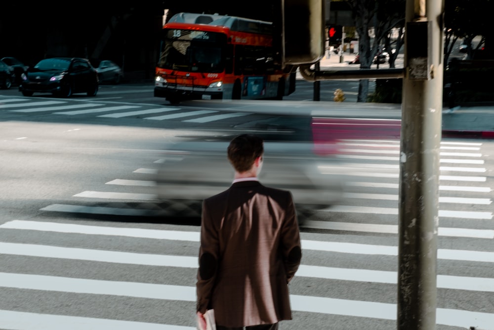 a man standing at a crosswalk waiting to cross the street