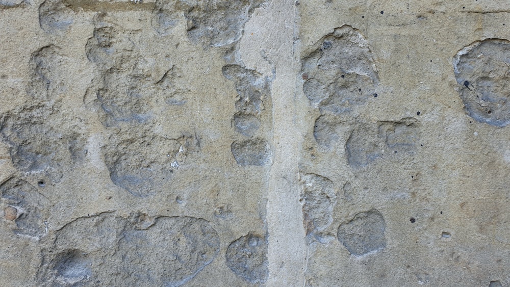 a close up of a stone wall with footprints on it
