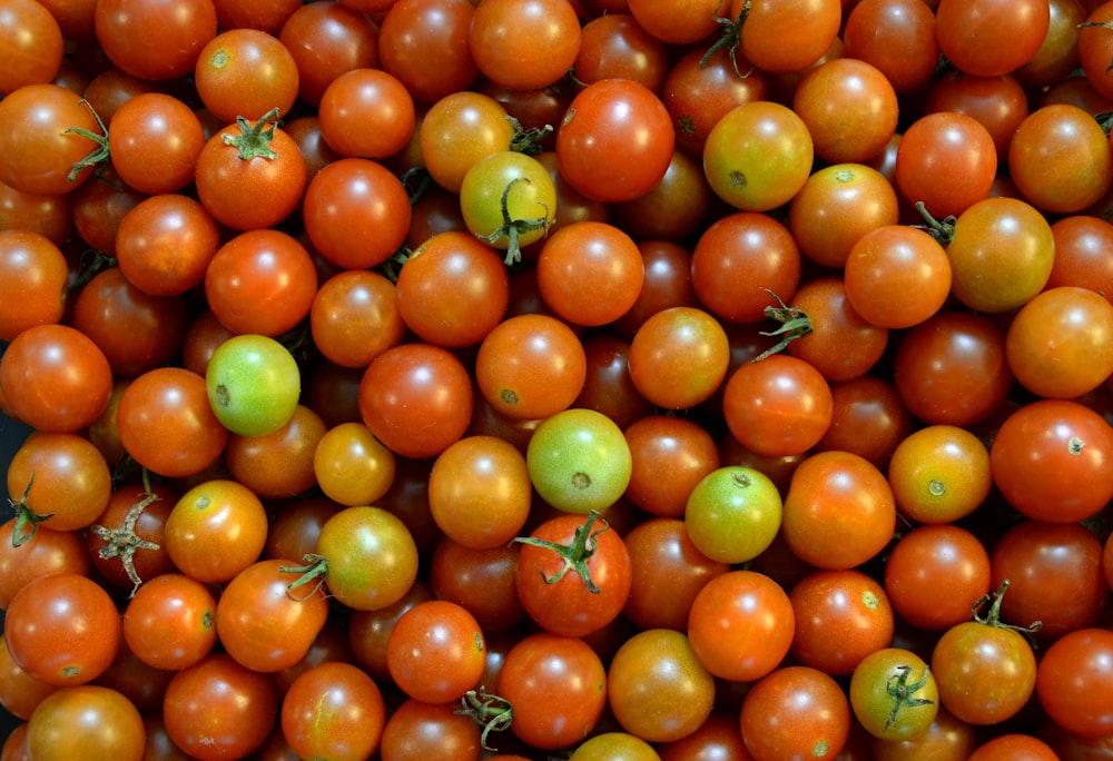 a bunch of tomatoes are piled up together