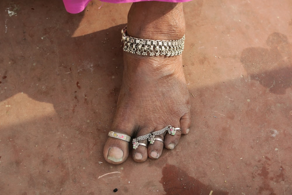 Un piede nudo di donna con un braccialetto su di esso