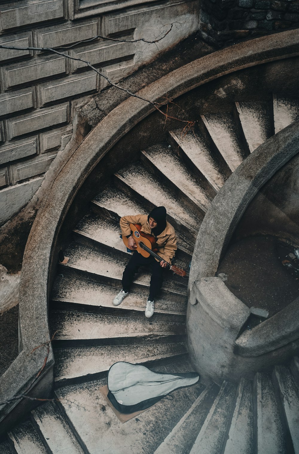 a man sitting on top of a spiral staircase