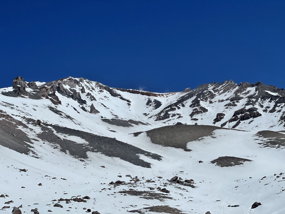 a mountain covered in snow under a blue sky