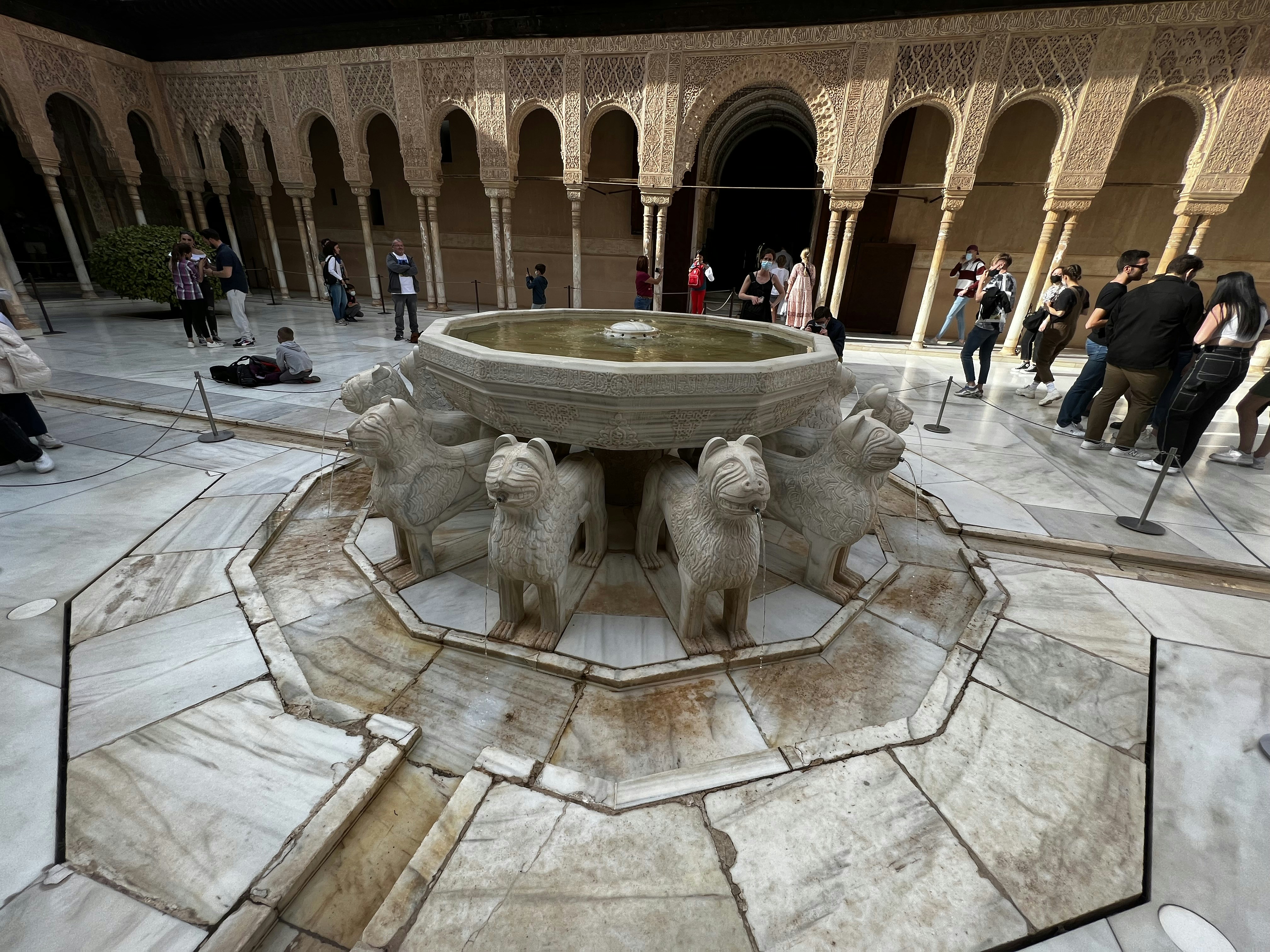 a group of people standing around a fountain