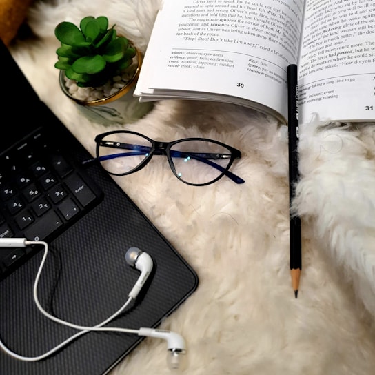 A cozy reading nook with an open Bible, headphones, and a laptop displaying a blog page.