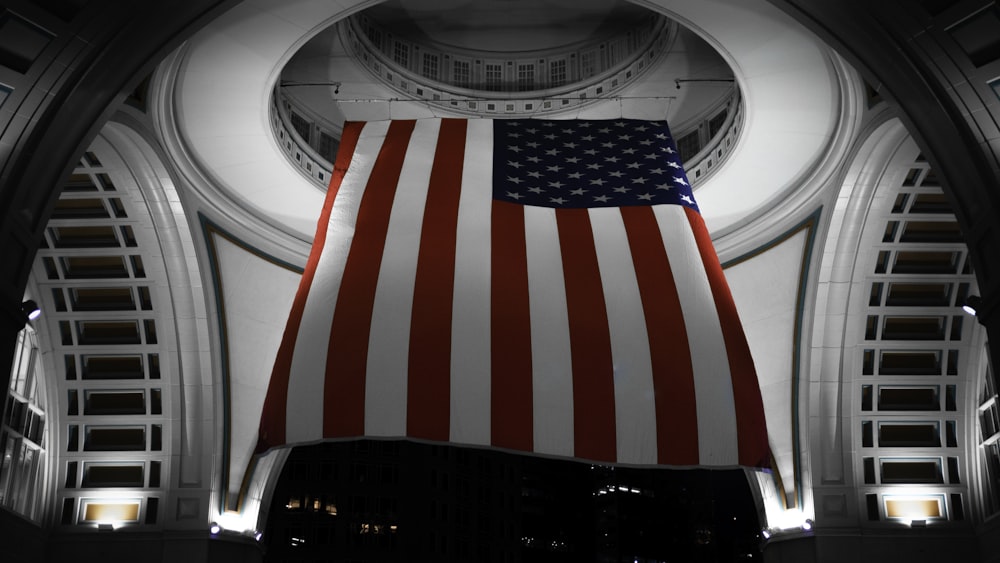 a large american flag hanging from the ceiling of a building