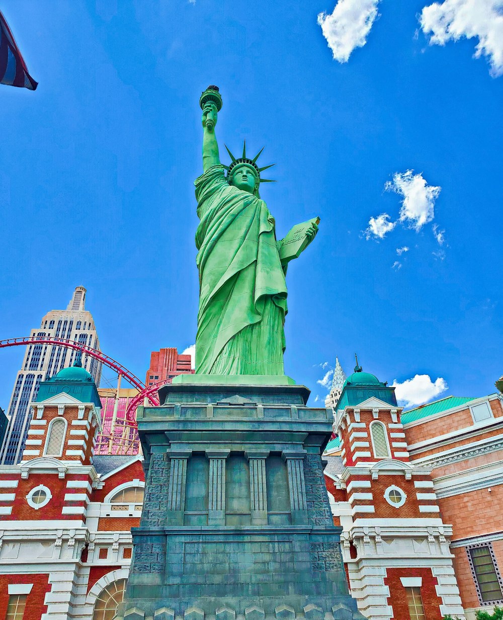 the statue of liberty stands in front of a large building