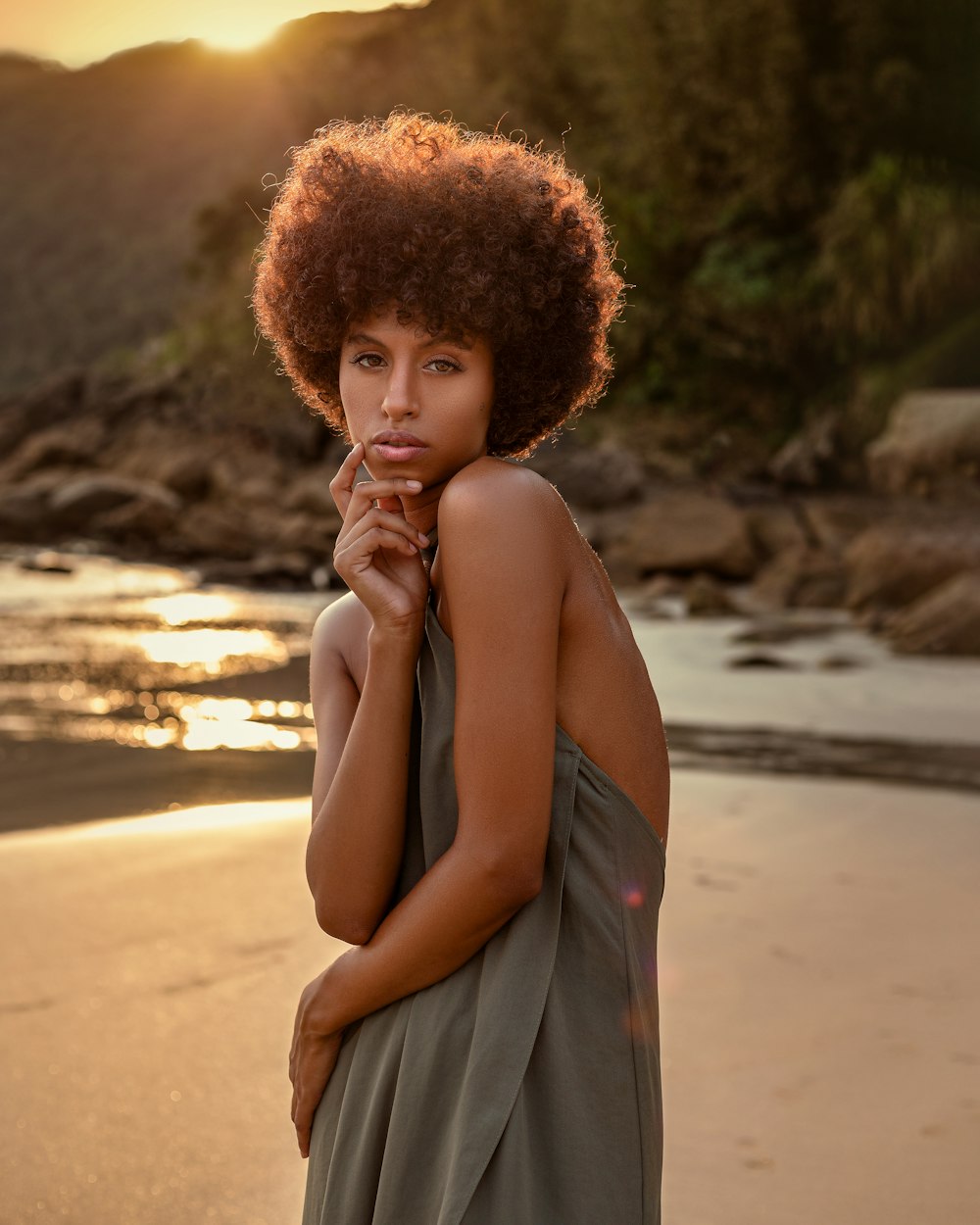 a woman with an afro standing on a beach