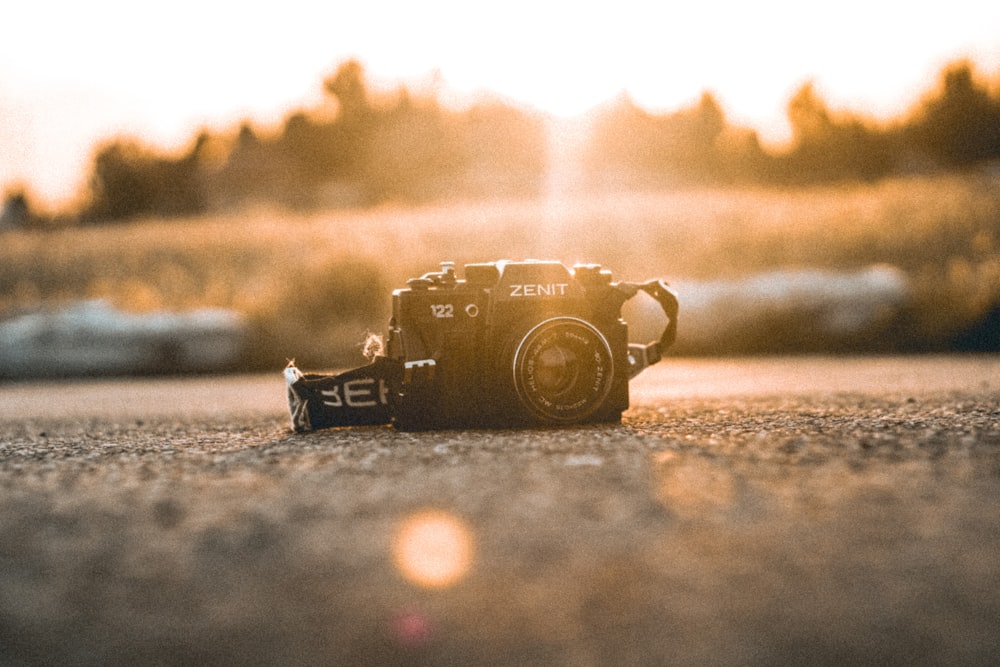 a camera sitting on the ground with the sun in the background