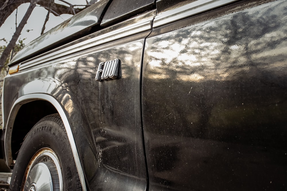 a close up of a black truck parked on the side of a road