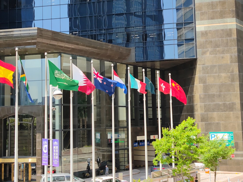 a bunch of flags that are in front of a building