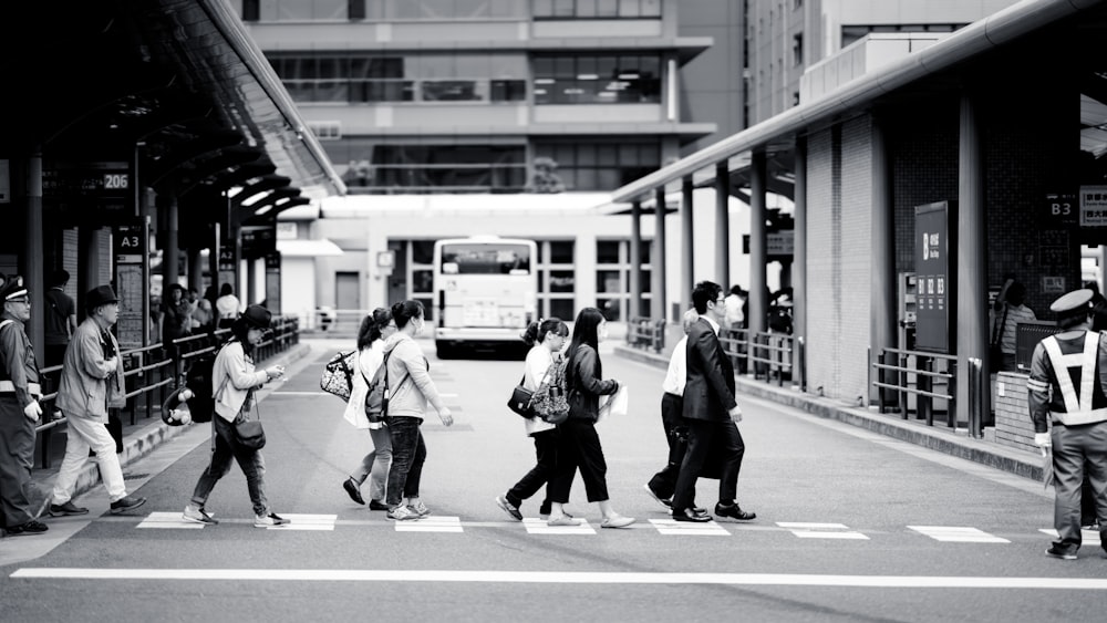 a group of people walking across a cross walk