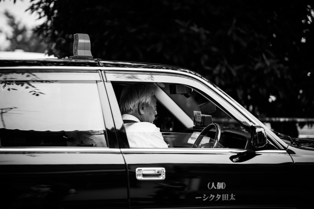 a woman sitting in the driver's seat of a taxi