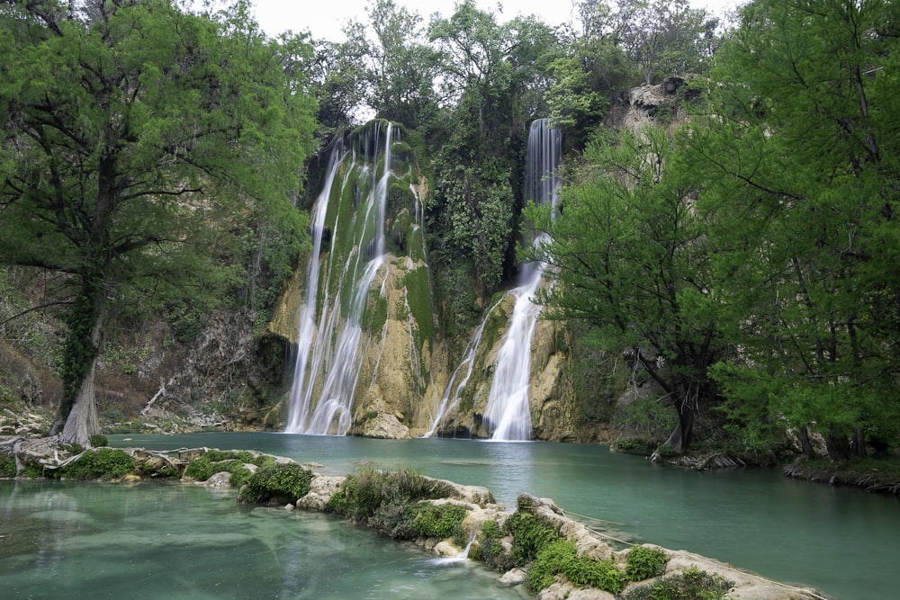 a large waterfall is in the middle of a river