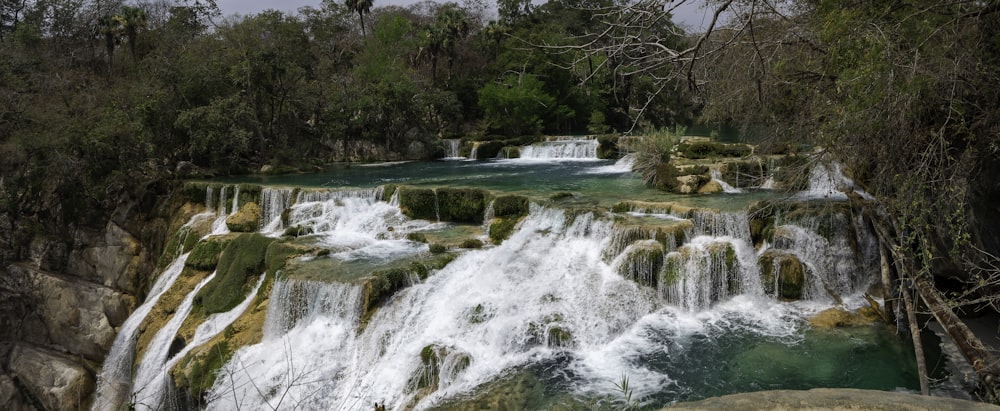 Eine Gruppe von Menschen steht vor einem Wasserfall