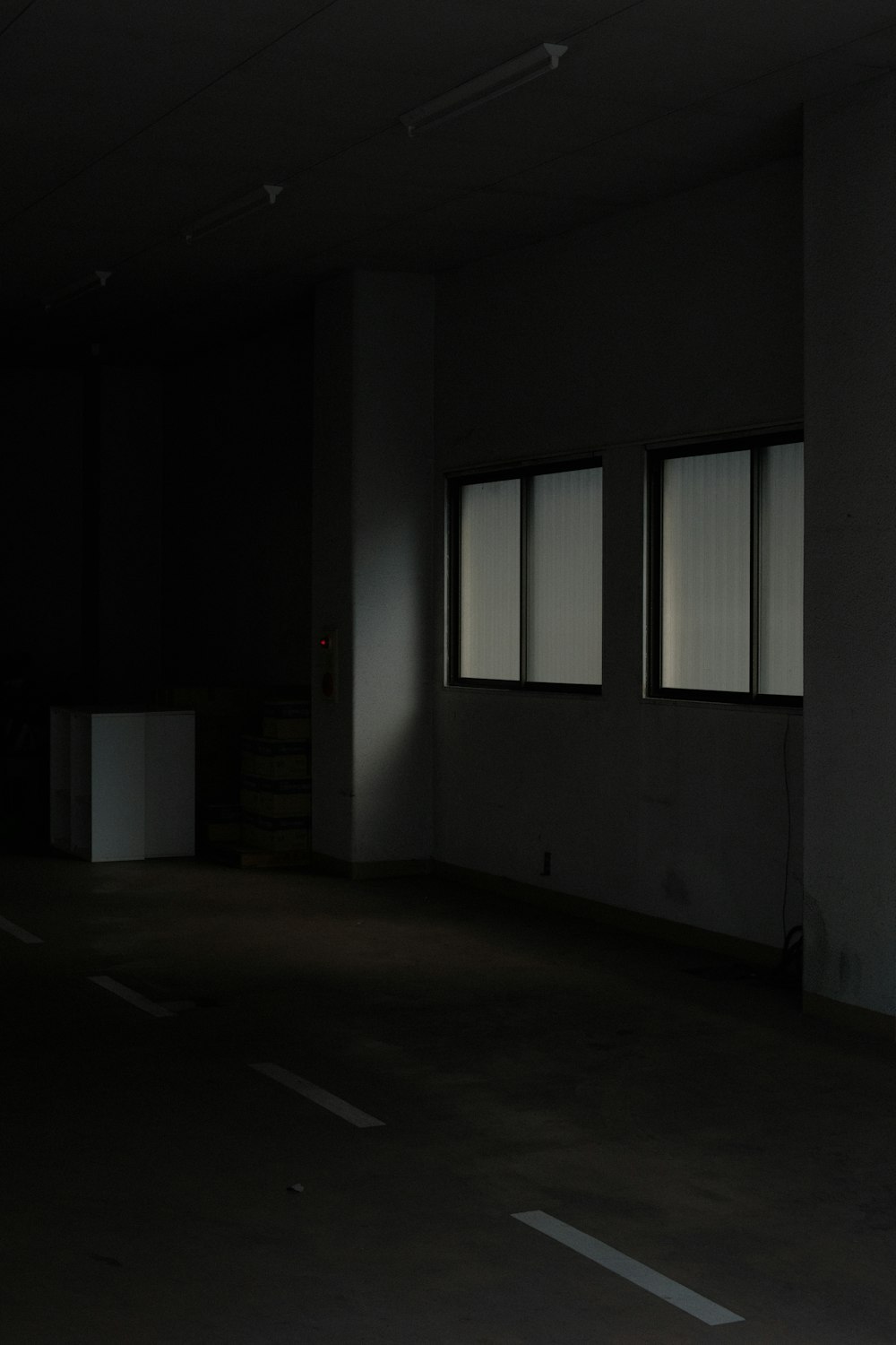 a dark room with three windows and no one in it