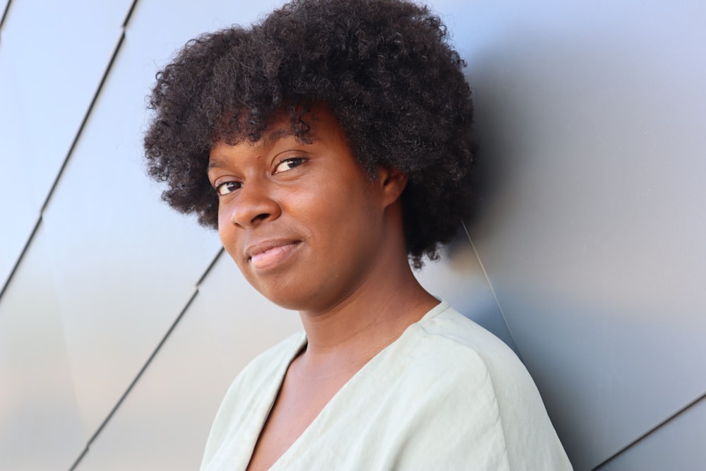 a woman leaning against a wall with a smile on her face