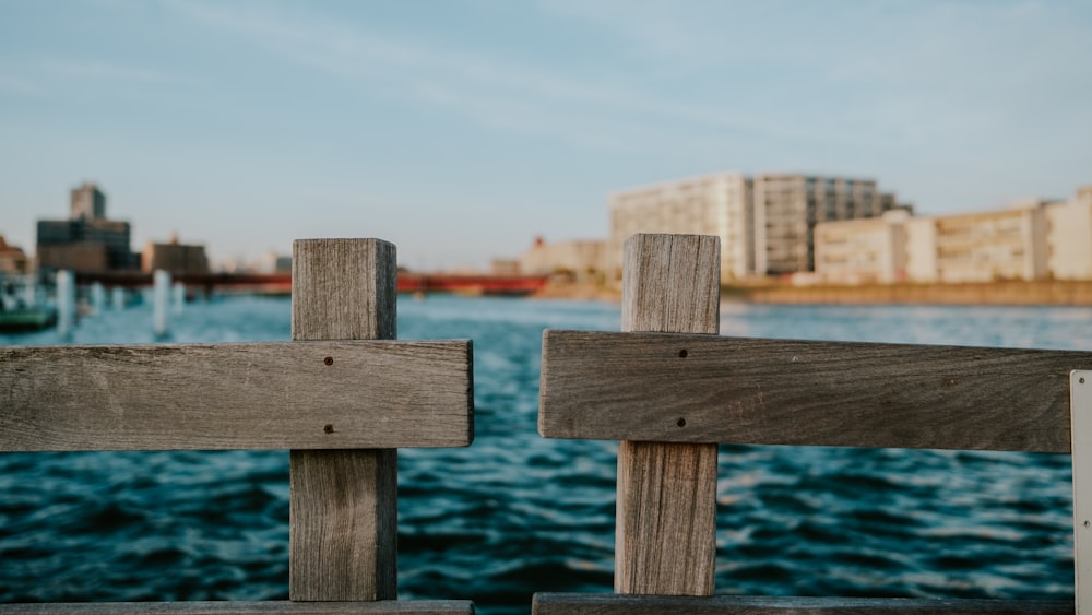 a close up of a wooden fence with a body of water in the background