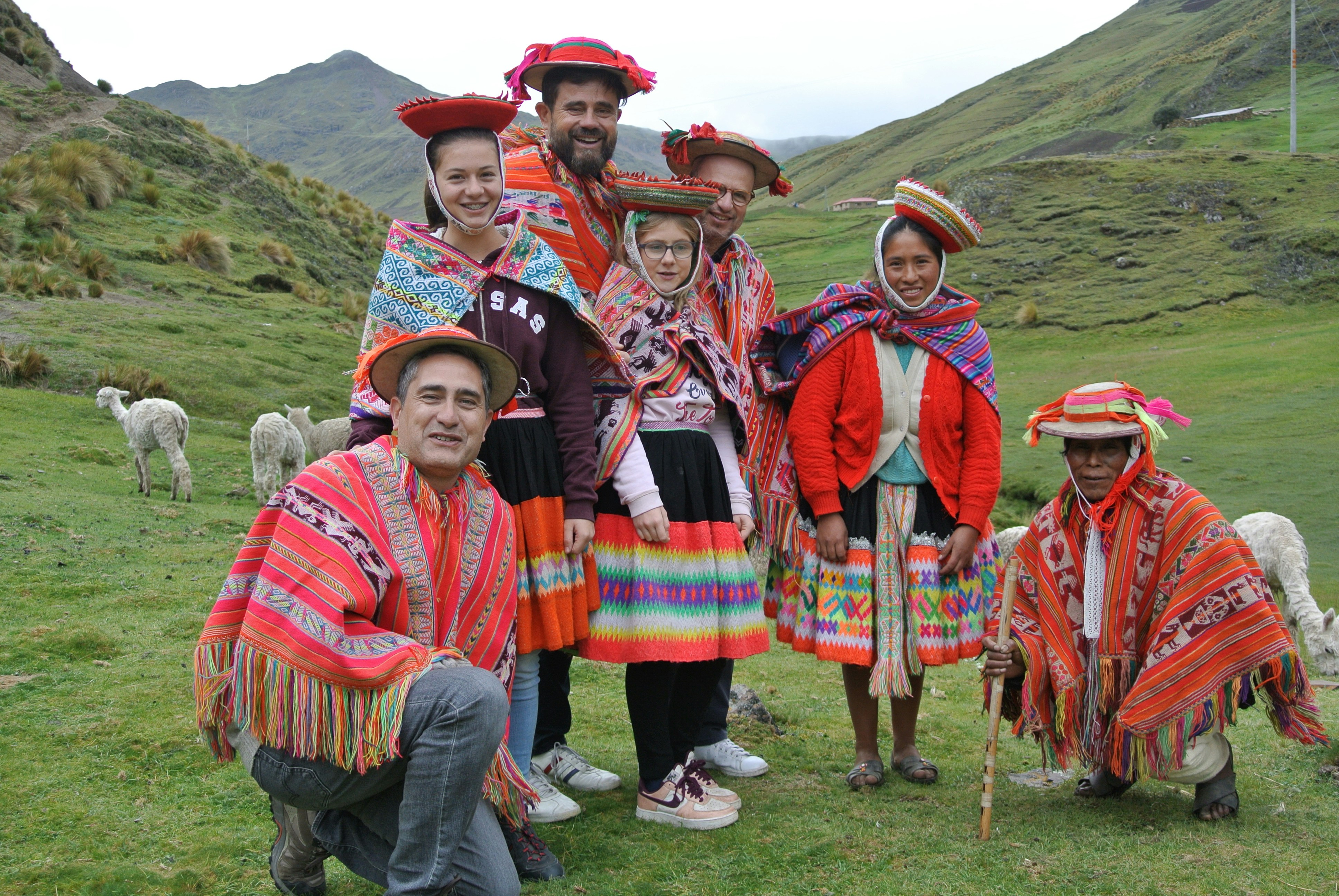a group of people standing on top of a lush green field