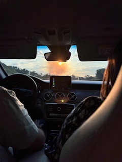 A fleet manager reviewing real-time GPS data on a tablet inside a truck cabin at sunset.