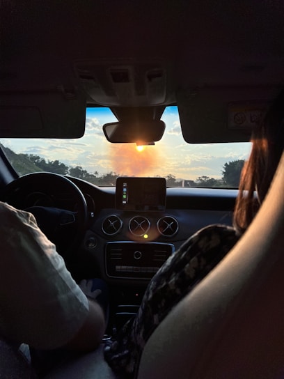 A fleet manager reviewing real-time GPS data on a tablet inside a truck cabin at sunset.