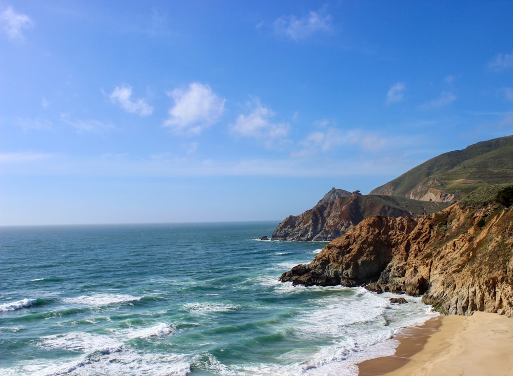 uma vista de uma praia com um penhasco no fundo