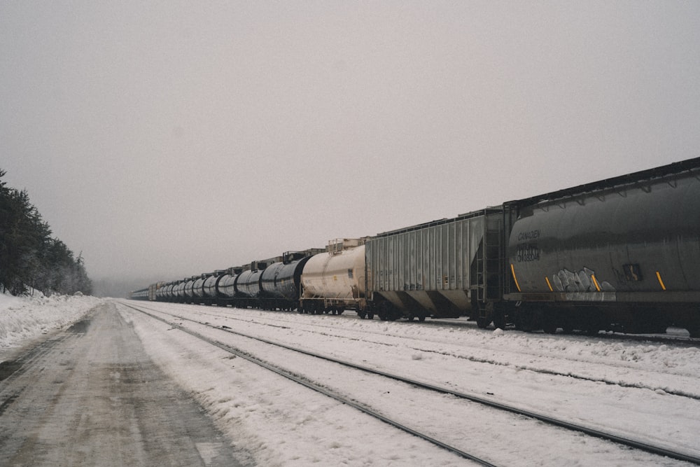 a train traveling down train tracks in the snow