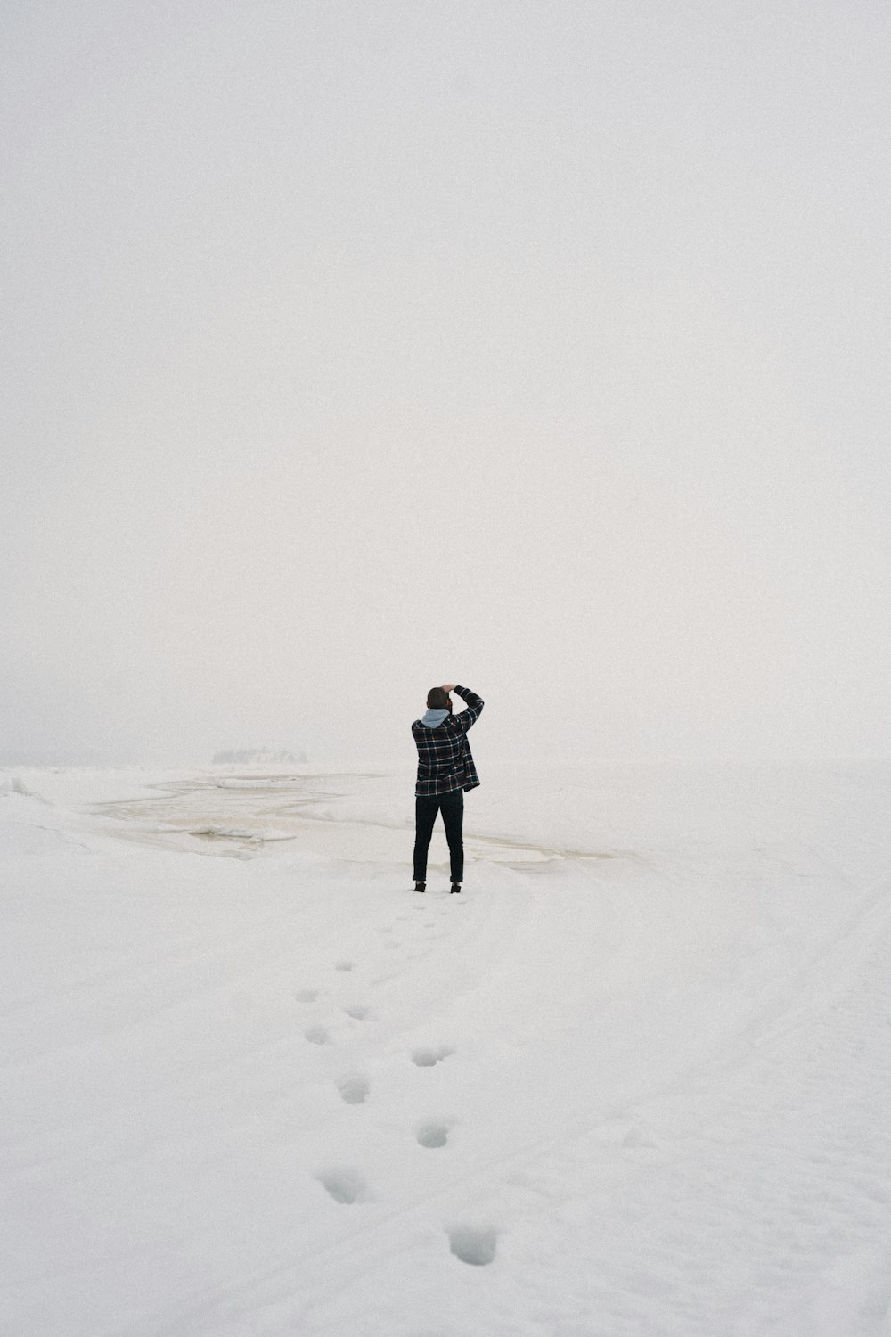 a person standing in the middle of a snowy field