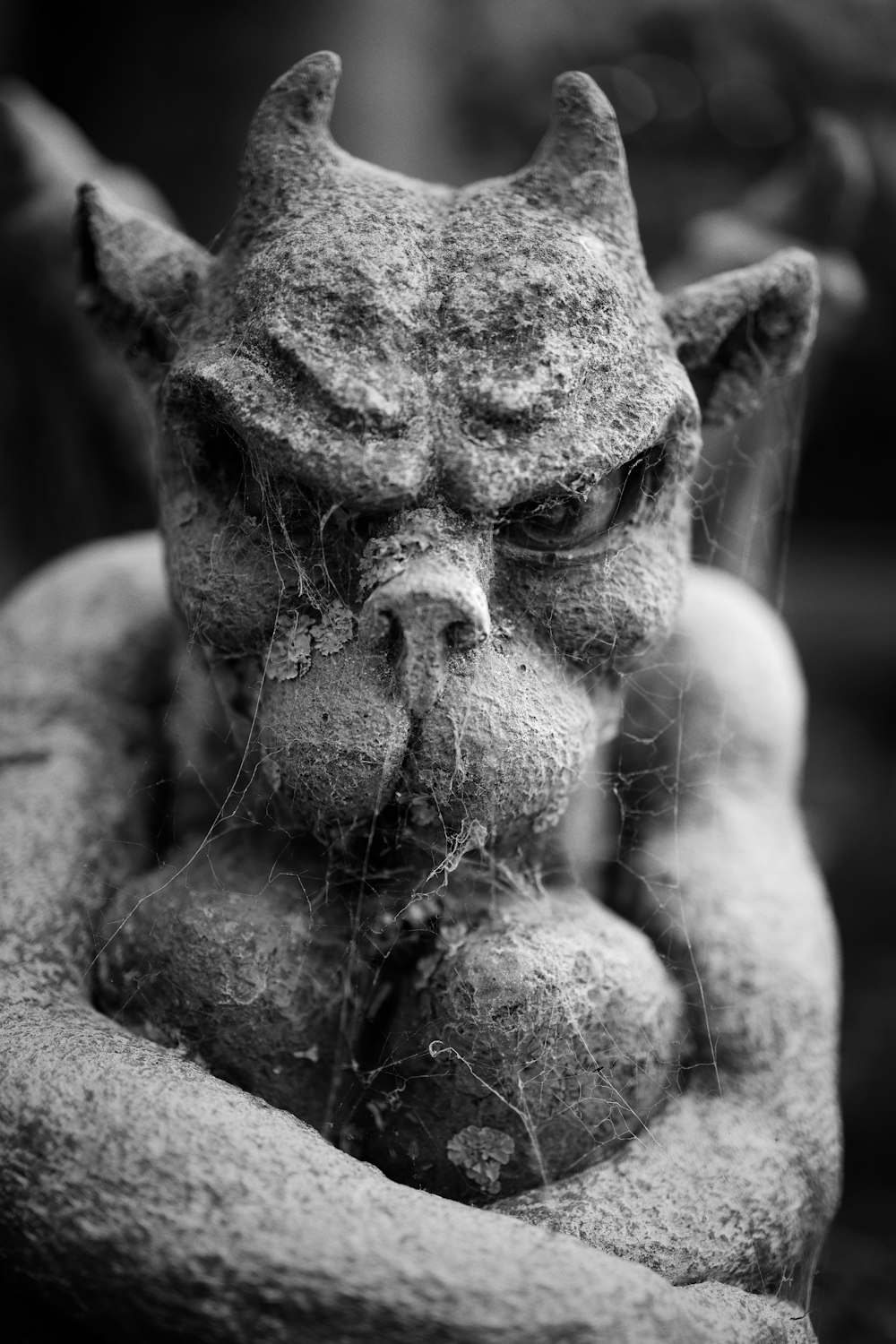 a black and white photo of a statue of a demon