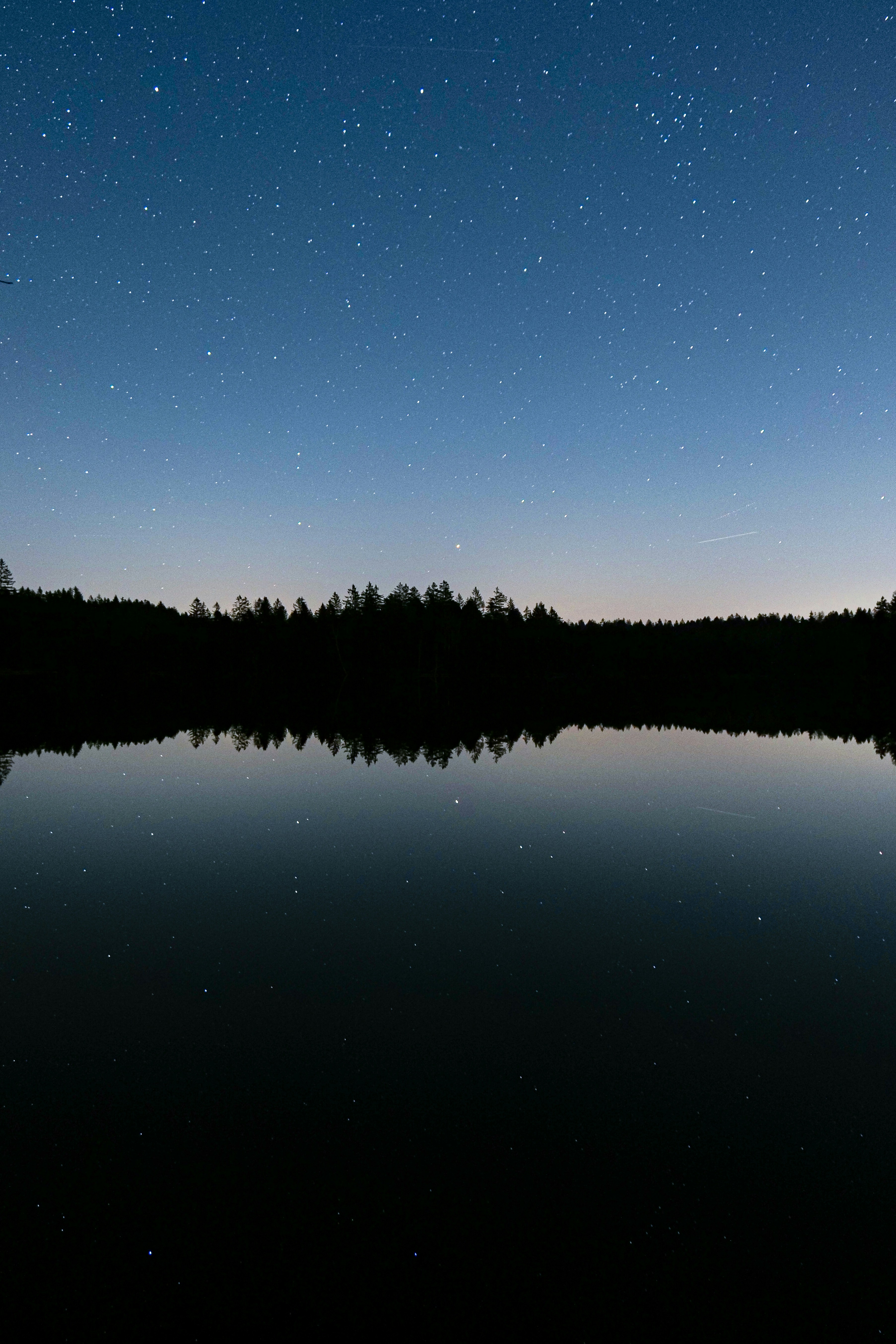 The night sky is reflected in the still water of a lake photo – Free  Forrest Image on Unsplash, image size:3000x4500