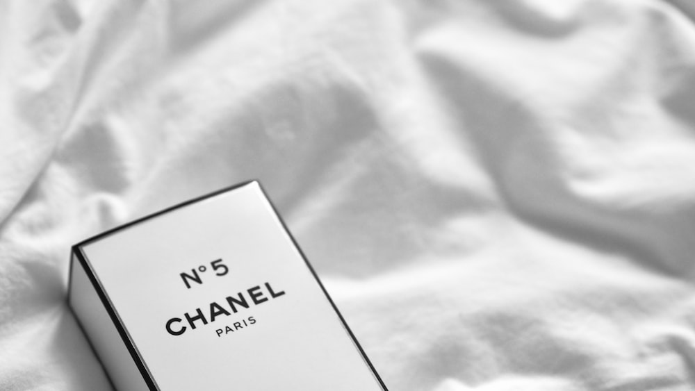 a box of chanel no 5 perfume on a bed