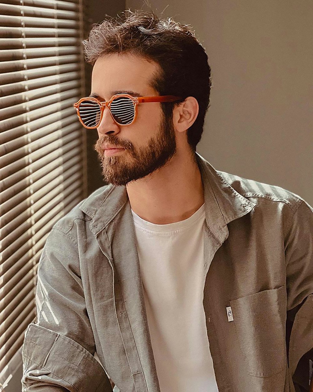 a man with a beard wearing sunglasses and a white t - shirt