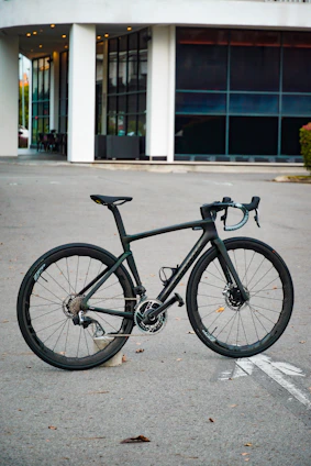 A sleek, modern professional cyclist riding a high-performance bike on an urban street.