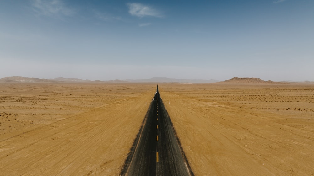 an aerial view of a road in the middle of the desert