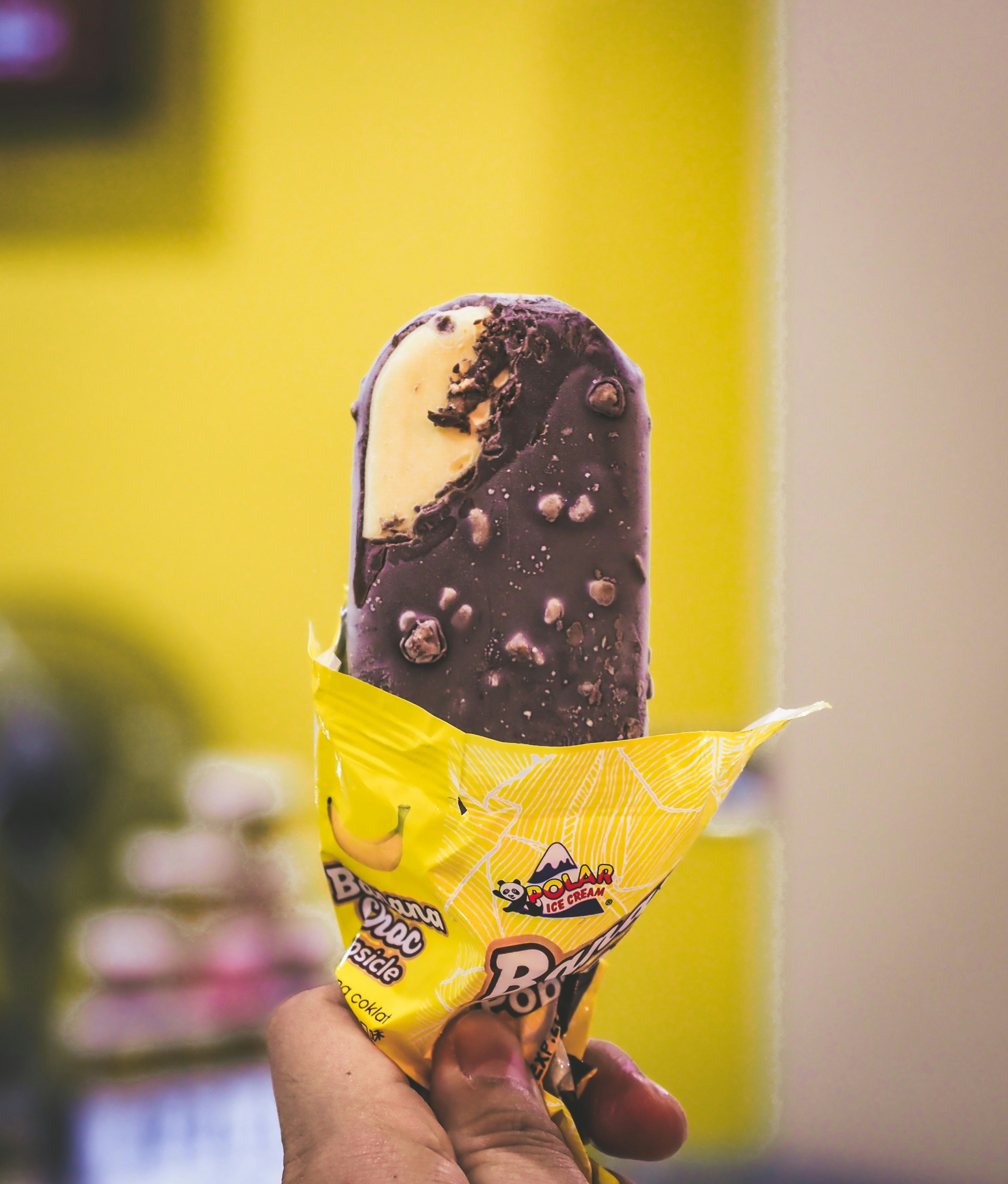 una persona che tiene un cono gelato ricoperto di cioccolato