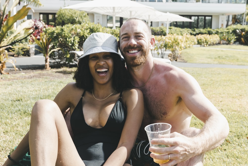 a man and a woman sitting on the grass