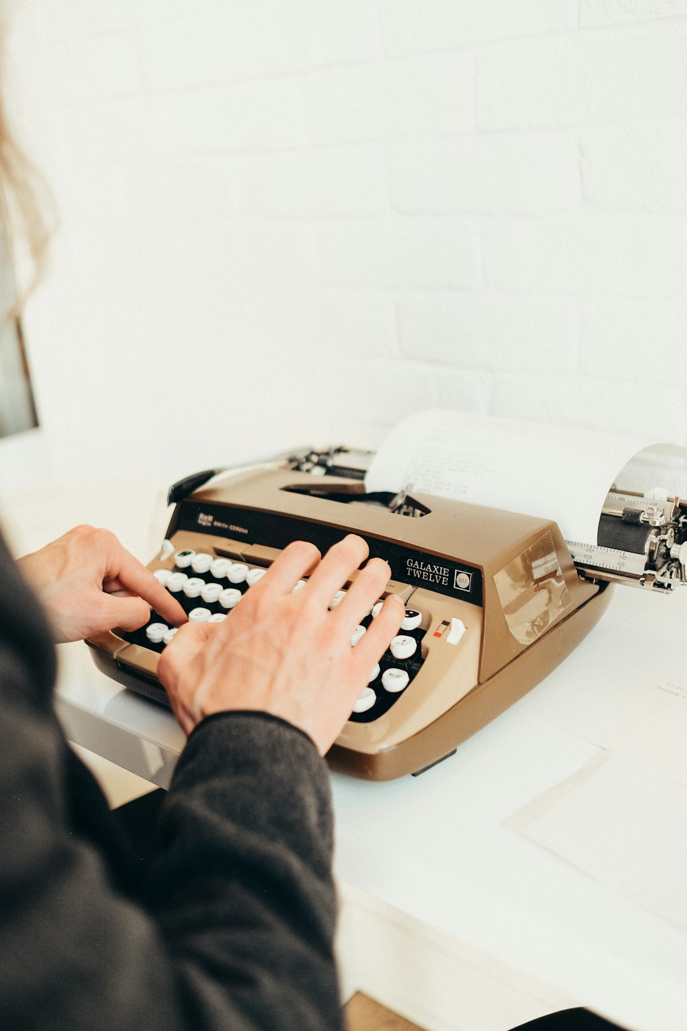 a person typing on an old fashioned typewriter