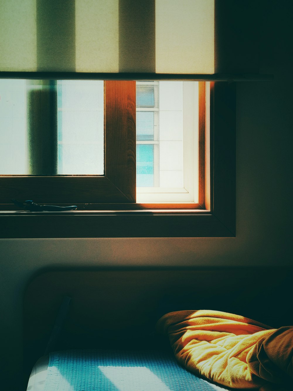 a bed sitting under a window next to a window