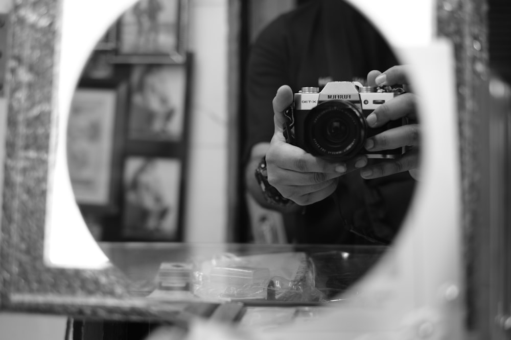 a person holding a camera in front of a mirror