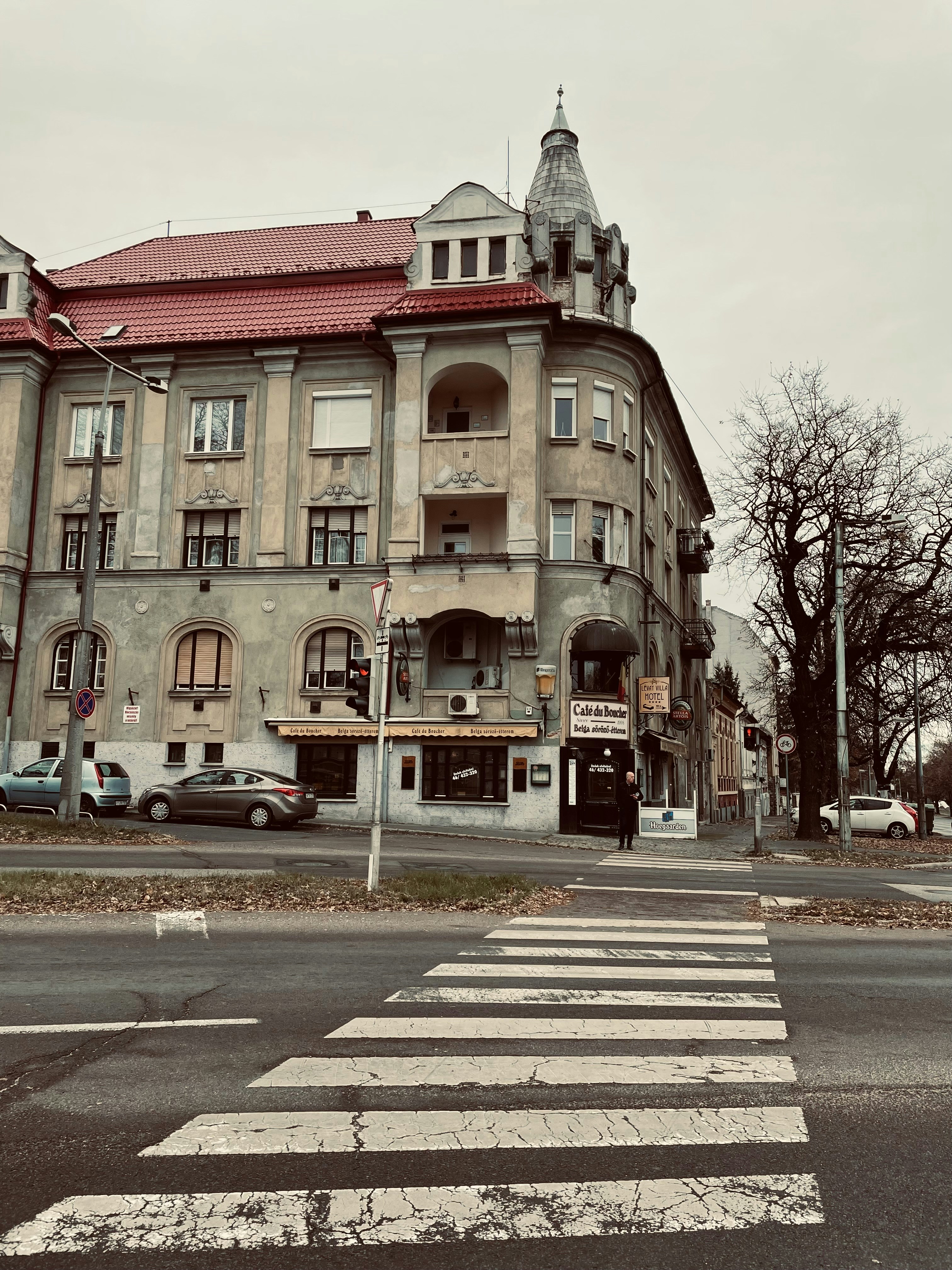 an old building with a red roof on a street corner