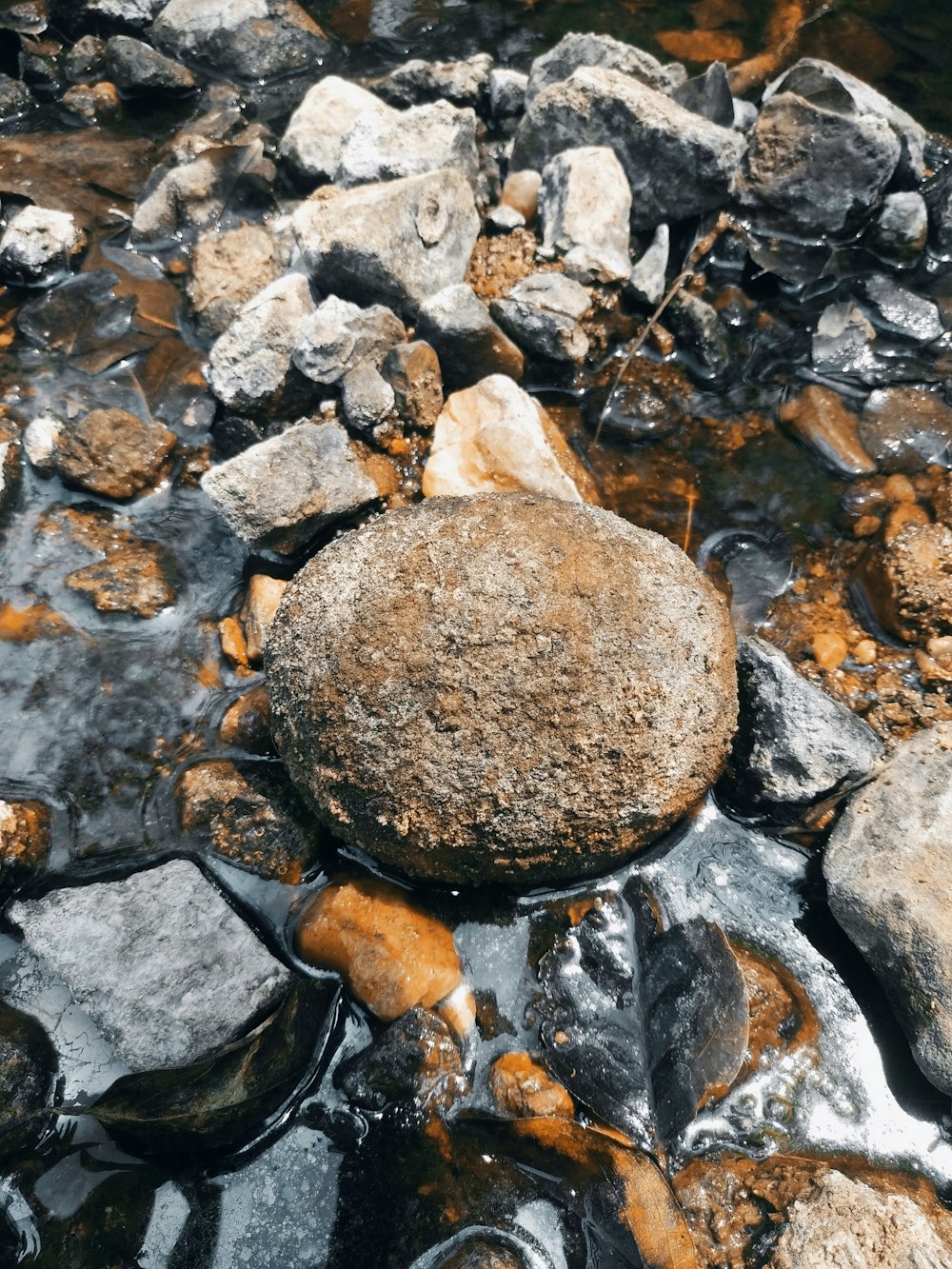 a rock sitting on top of a rocky river