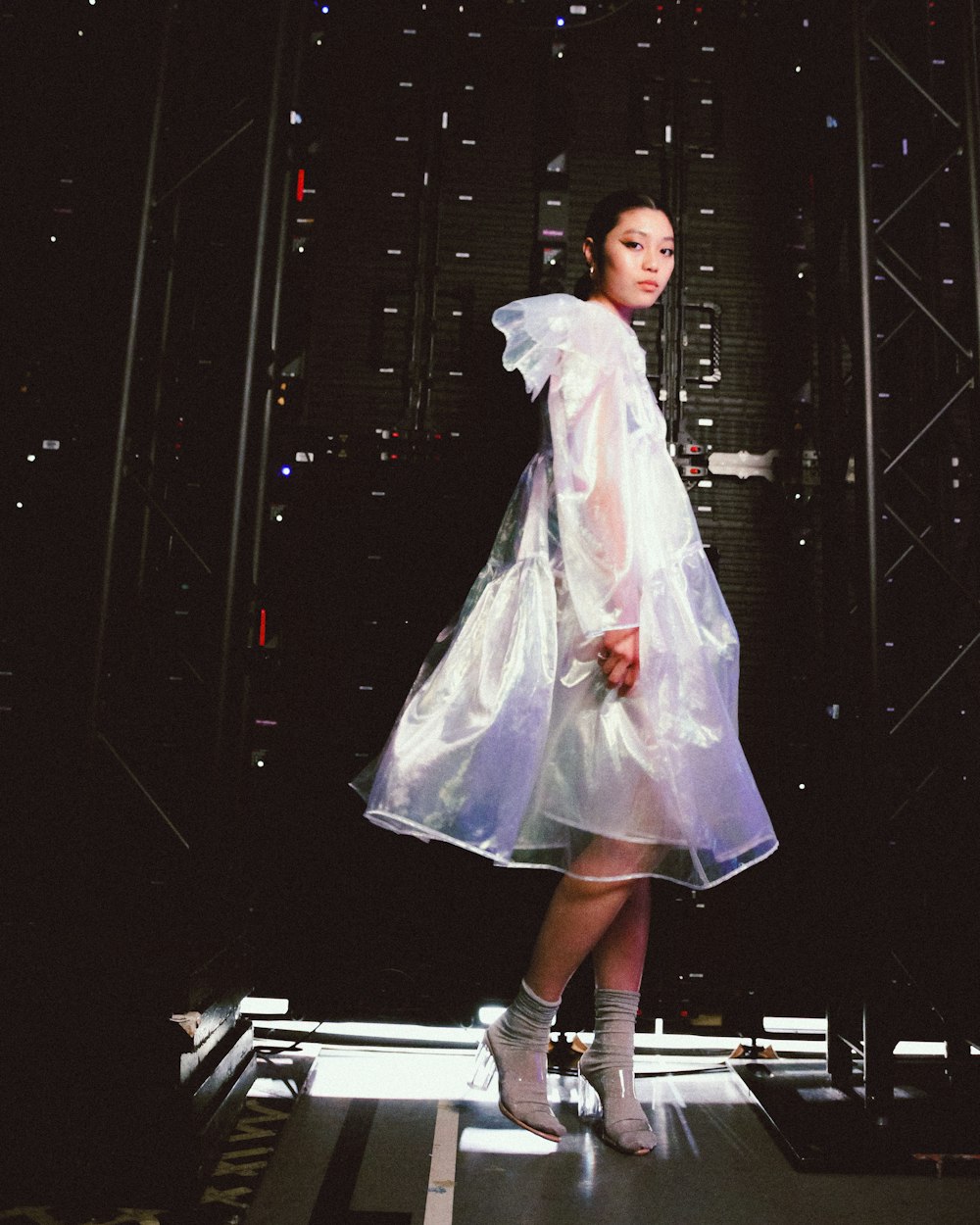 a woman in a white dress is standing on a stage