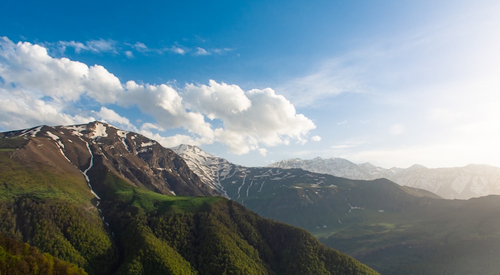 a view of a mountain range with snow capped mountains in the background