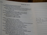 An open page of a book displaying text from a biblical psalm. The page includes verse numbers and a section for notes with handwriting visible on the right. The main text discusses themes of weakness, enemies, and trust in God.