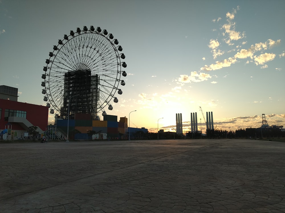 a large ferris wheel sitting next to a tall building