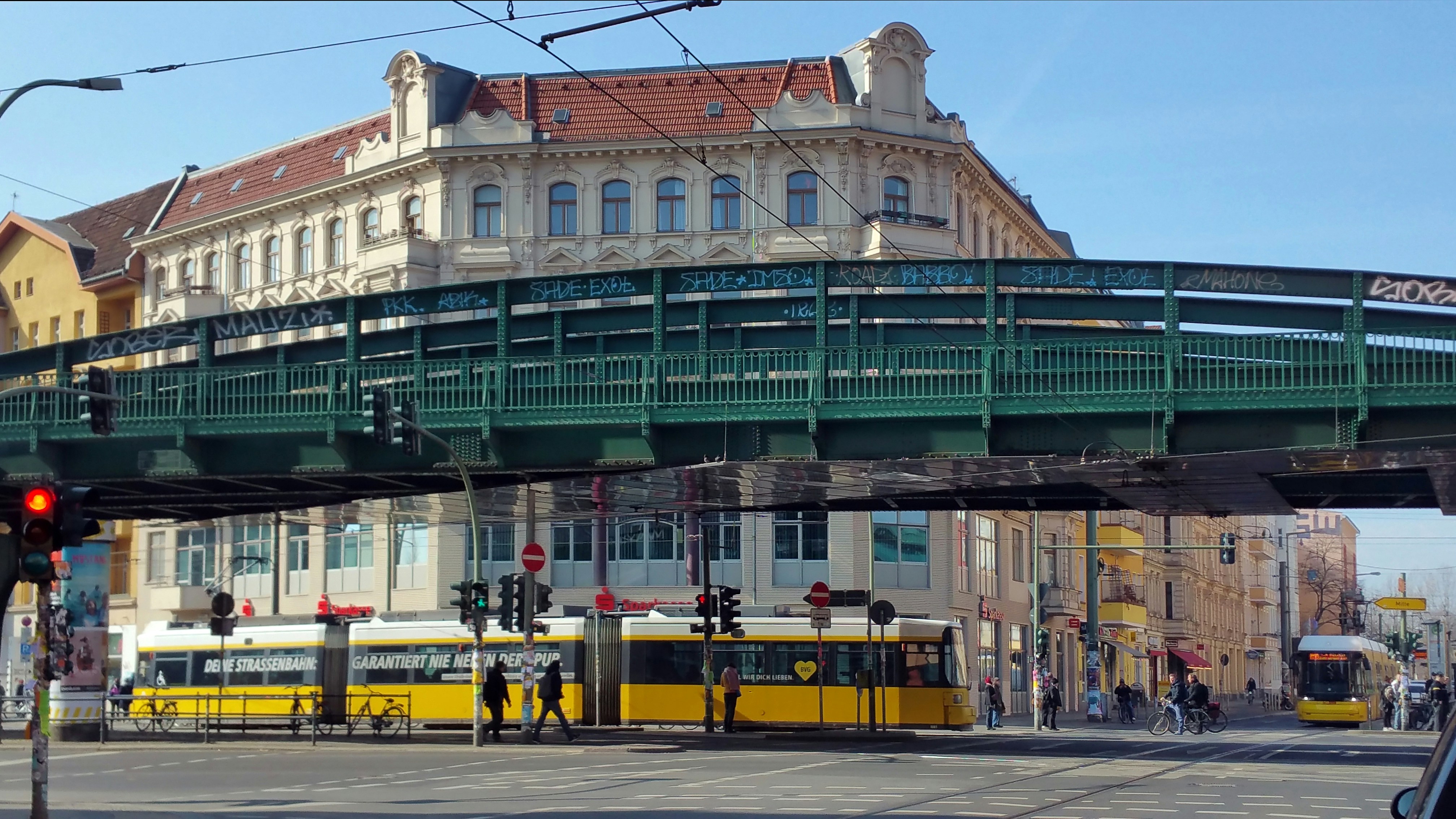 a green pedestrian bridge over a busy city street, Eberswalder Straße, Berlin, Germany