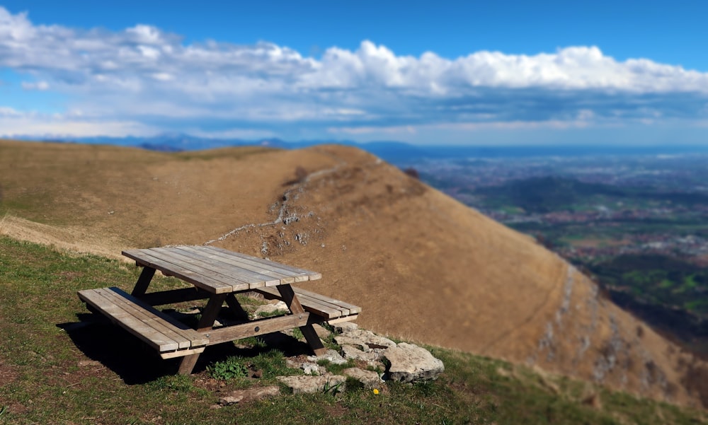 a picnic table sitting on top of a grass covered hillside