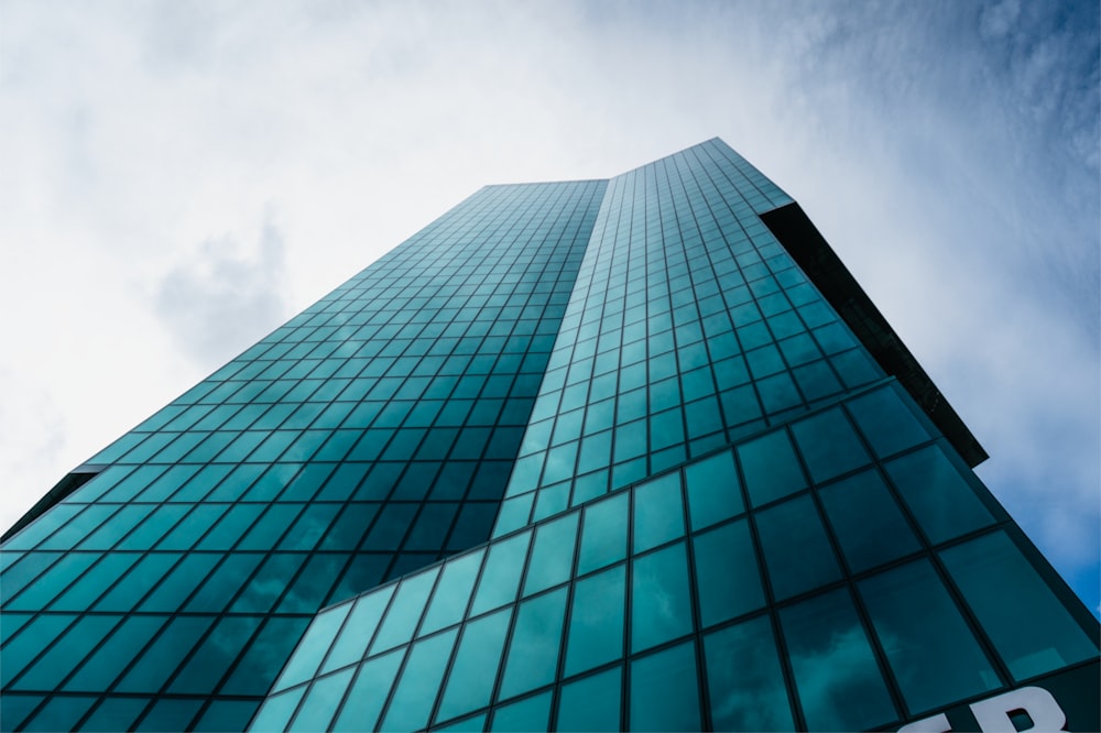 a tall glass building with a sky background