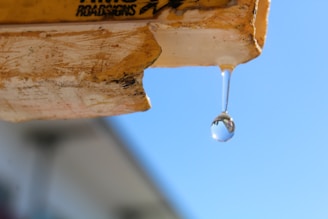 a drop of water hanging from the side of a building