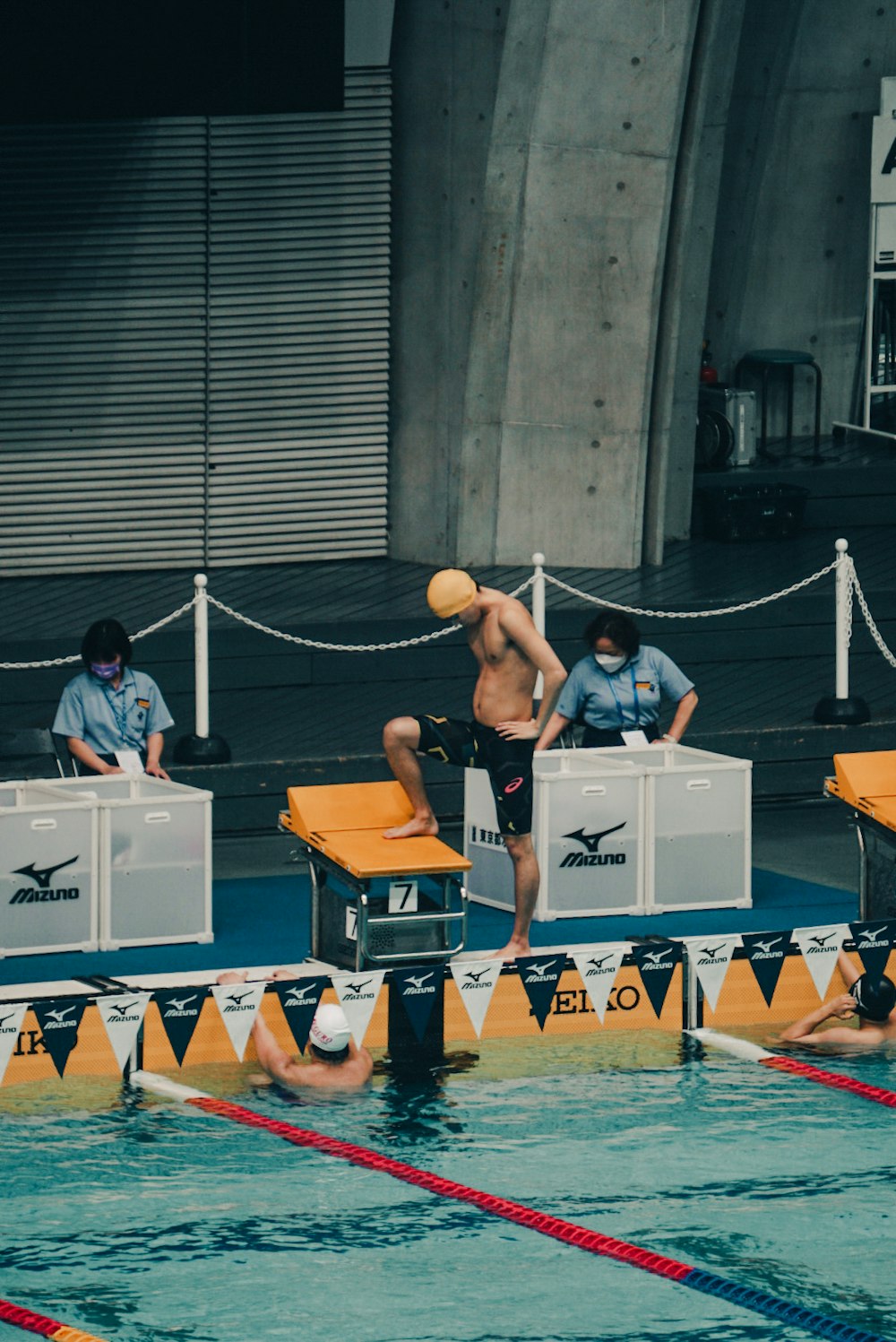 a group of men standing on top of a swimming pool